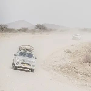 Desert Prints: Cars on a dusty desert road in Namibia