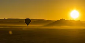 Mountains Prints: A hot-air balloon at sunrise in the Namib Naukluft area of Namibia